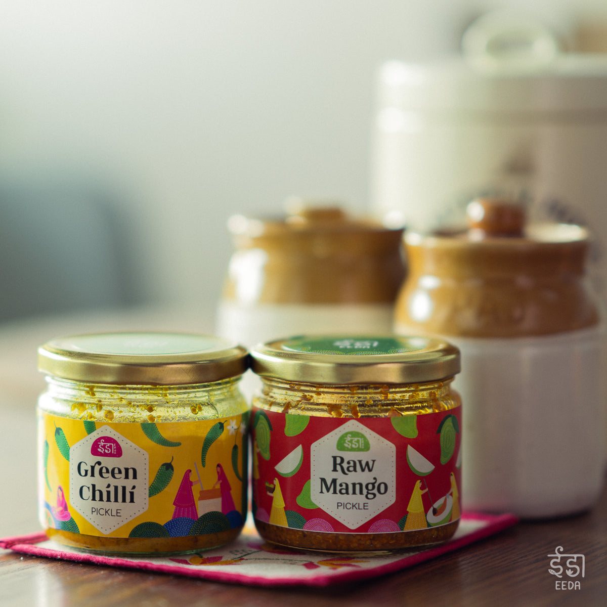 Eeda Green Chilli and Raw Mango pickle jars side by side