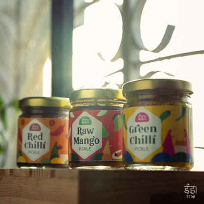 Eeda Red Chilli, Raw Mango and Green Chilli pickle jars by a window