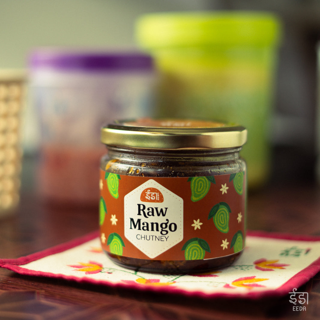 Jar of Eeda Launji (raw mango chutney) on an embroidered coaster